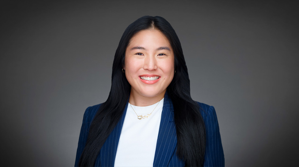 Woman with long black hair smiling in a navy pinstriped blazer and white shirt Woman with long black hair smiling in a navy pinstriped blazer and white shirt