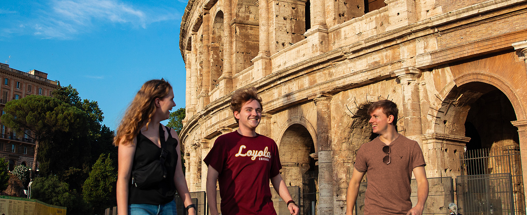 Loyola students walk next to the iconic Rome Coliseum