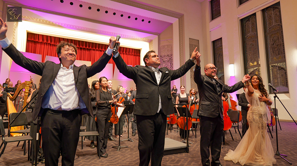 Performers from Una Noche de Encanto raise their hands together as they bow during standing ovation. Performers from Una Noche de Encanto raise their hands together as they bow during standing ovation.
