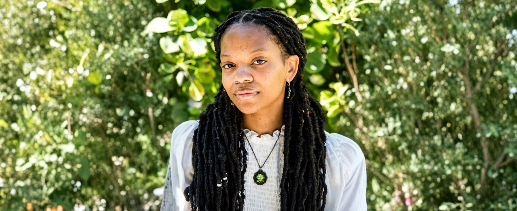 Amélie Malone smiles against a backdrop of greenery outside. Amélie Malone smiles against a backdrop of greenery outside.