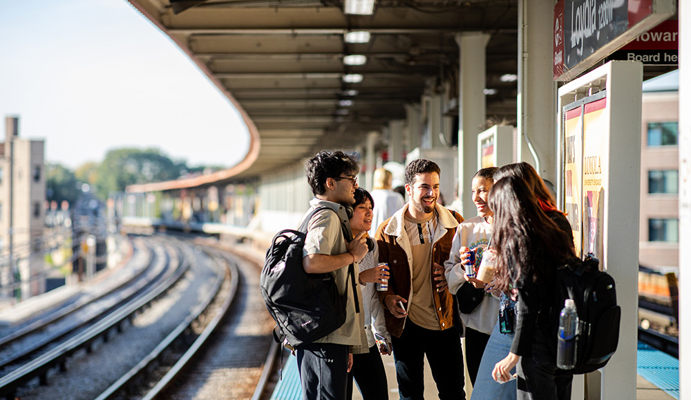 A group of students gather and chat on the Loyola A group of students gather and chat on the Loyola