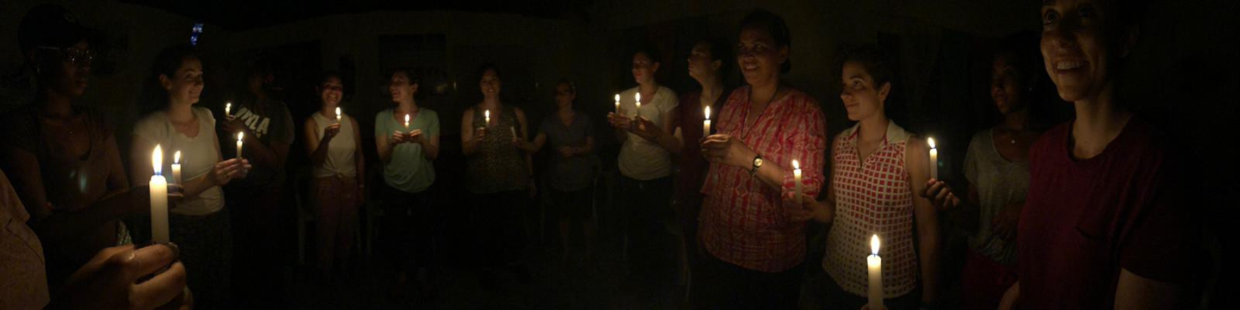 Students holding candles for group prayer