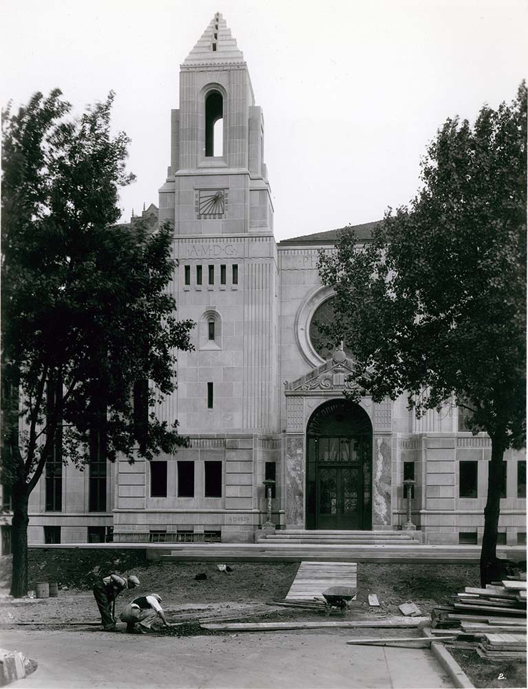 Exterior view showing two men working on the construction of Cudahy Library's original entrance