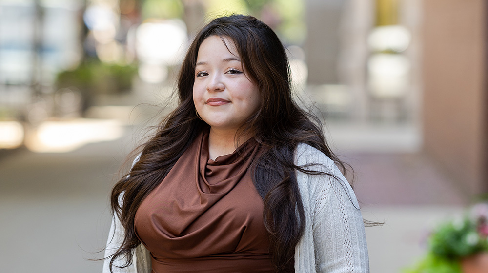 Student posing outside in front of Arrupe College of Loyola University Chicago