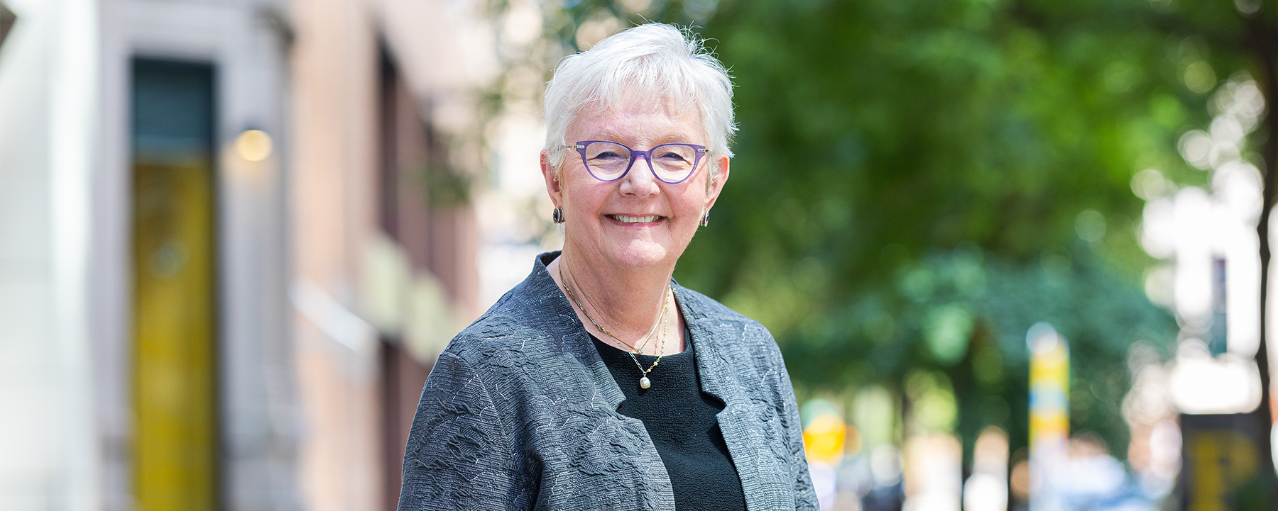 Mary Jane Theis, Chief Justice of the Supreme Court of Illinois, stands on a city sidewalk