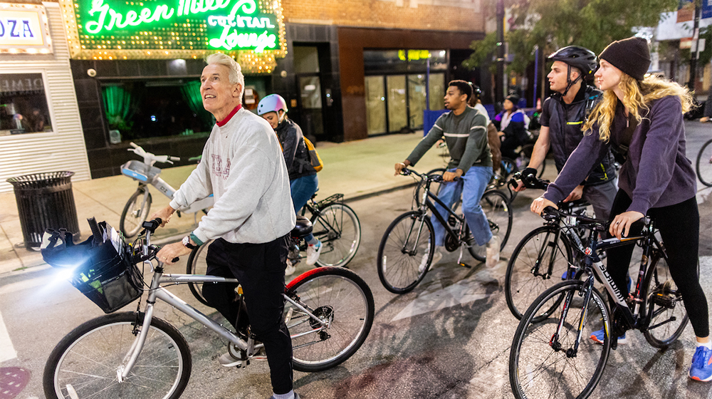 Timothy Gilfoyle guides a group of students on a bike tour on Broadway Avenue outside the historic Green Mill