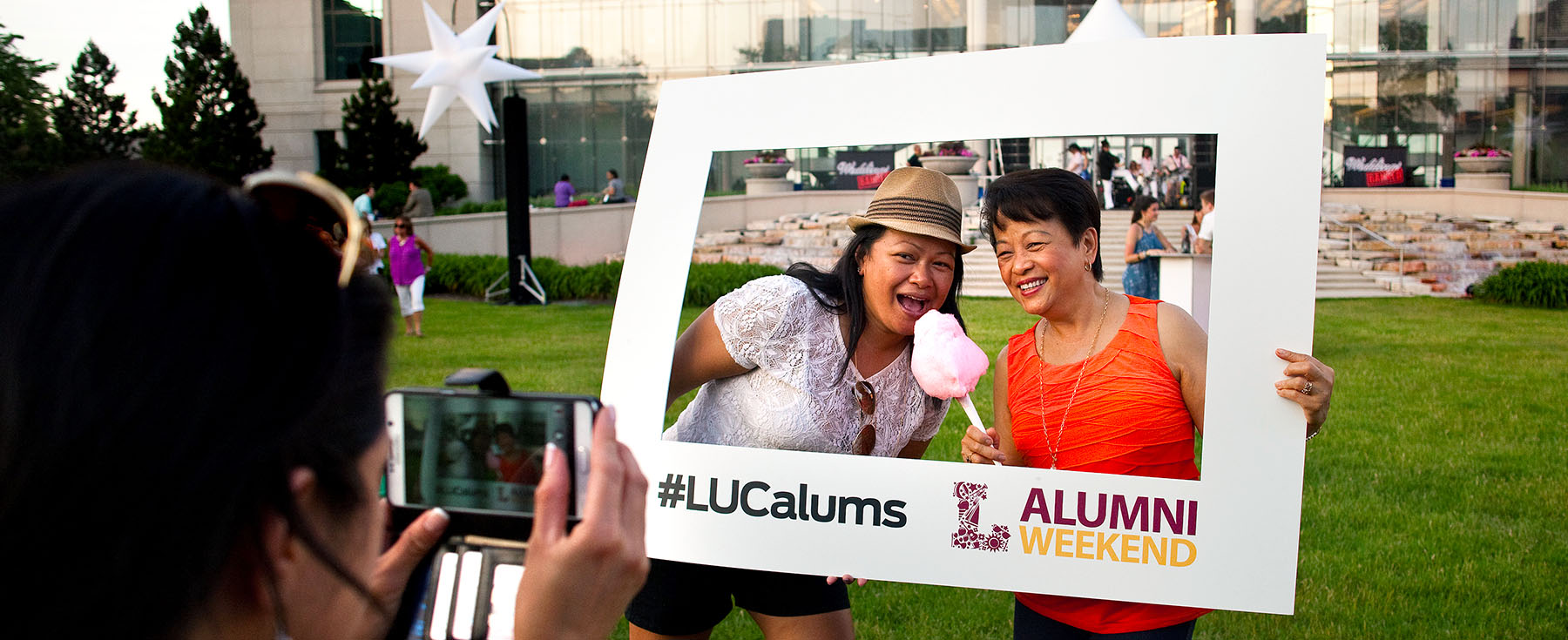 Alumni standing in front of the Information Commons posing for a picture