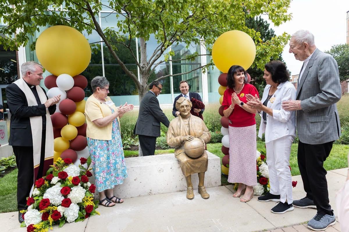 People gather around the new statue of Sister Jean on Loyola's Campus