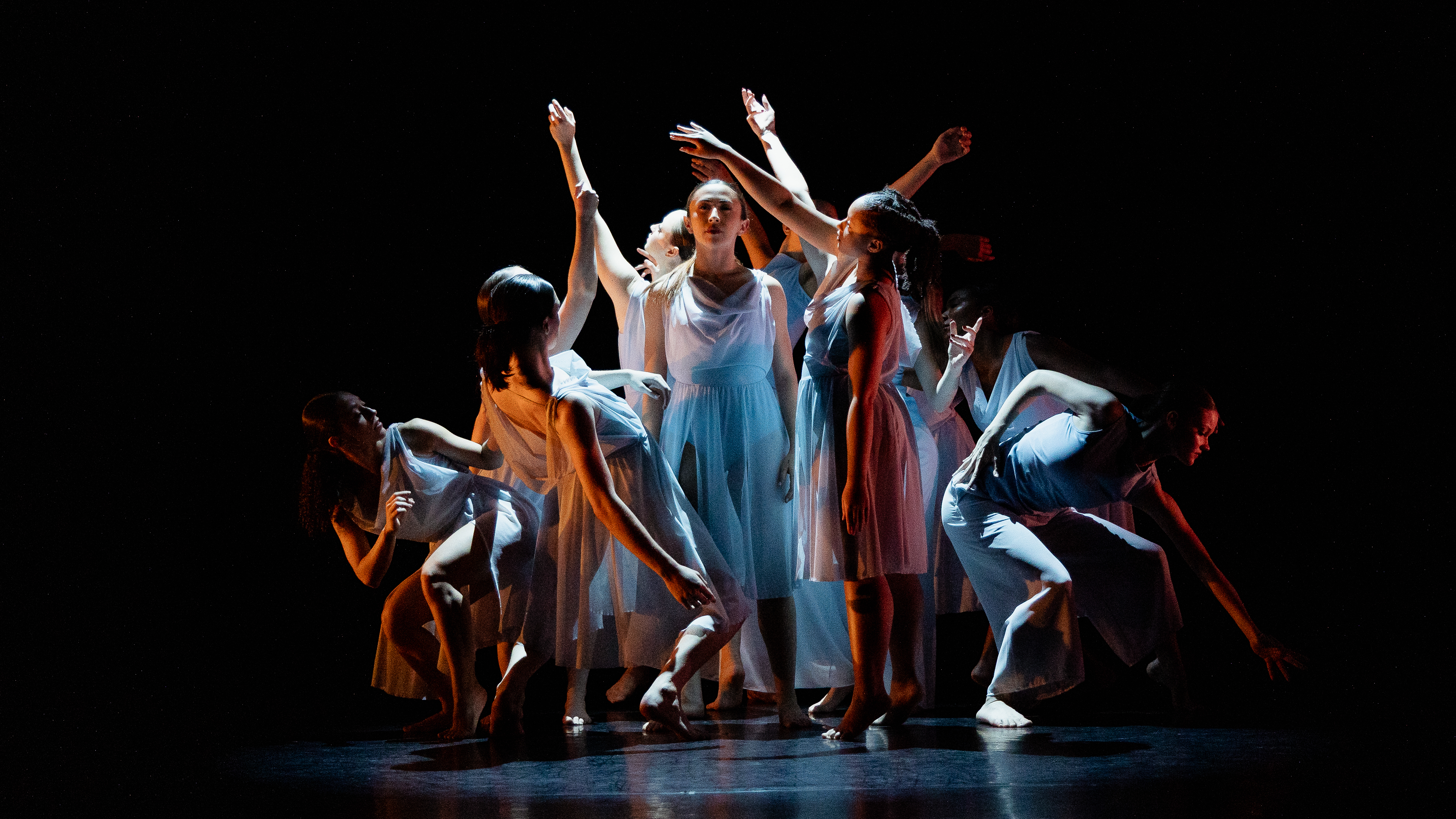 Loyola Dance Students taking on different poses around a central dancer