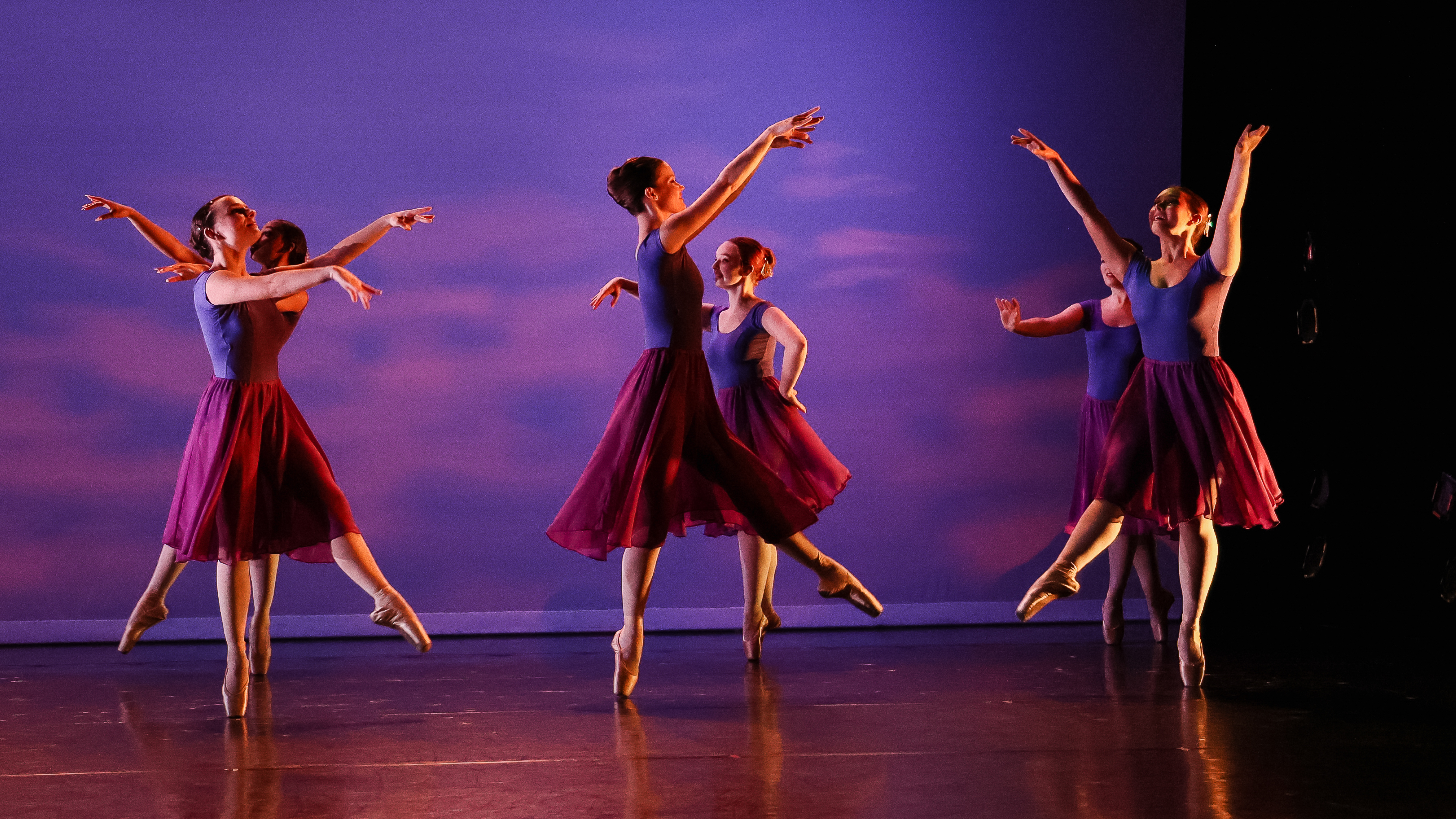 Loyola Dance Students performing in front of a projection of the sky on the Newhart Family Theatre stage