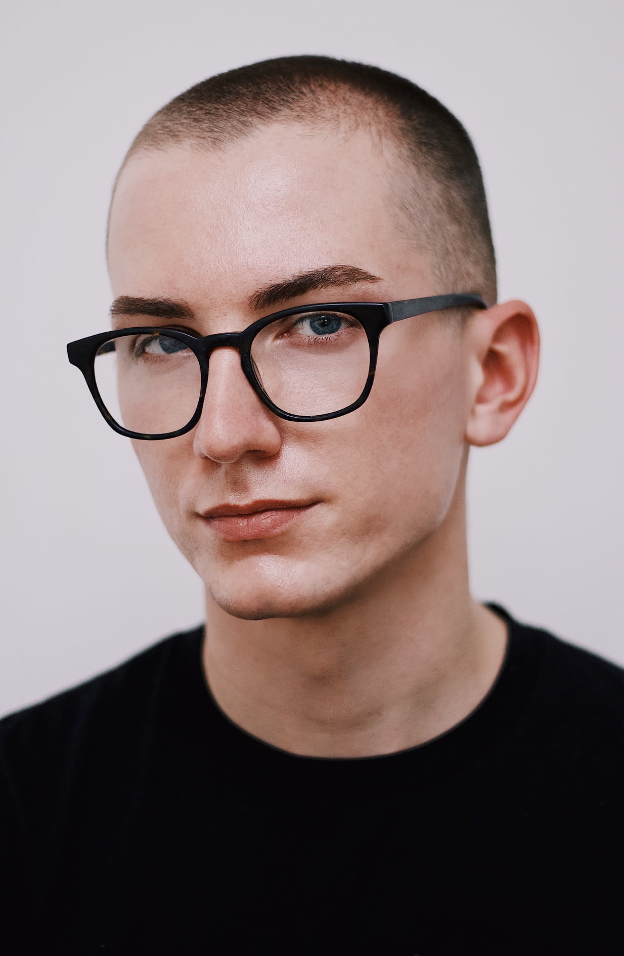 Robert Williams wearing a black t-shirt sitting in front of a white backdrop