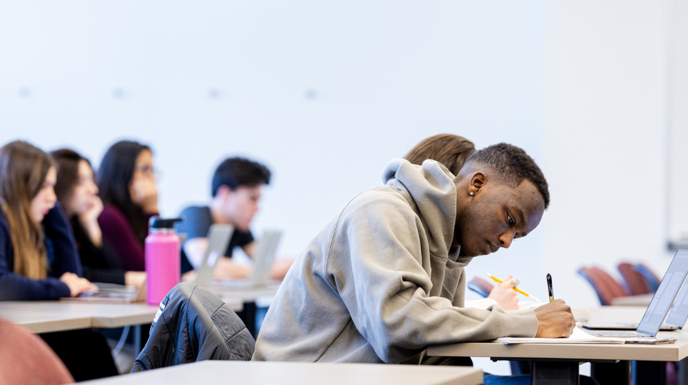 A student takes notes in the classroom.