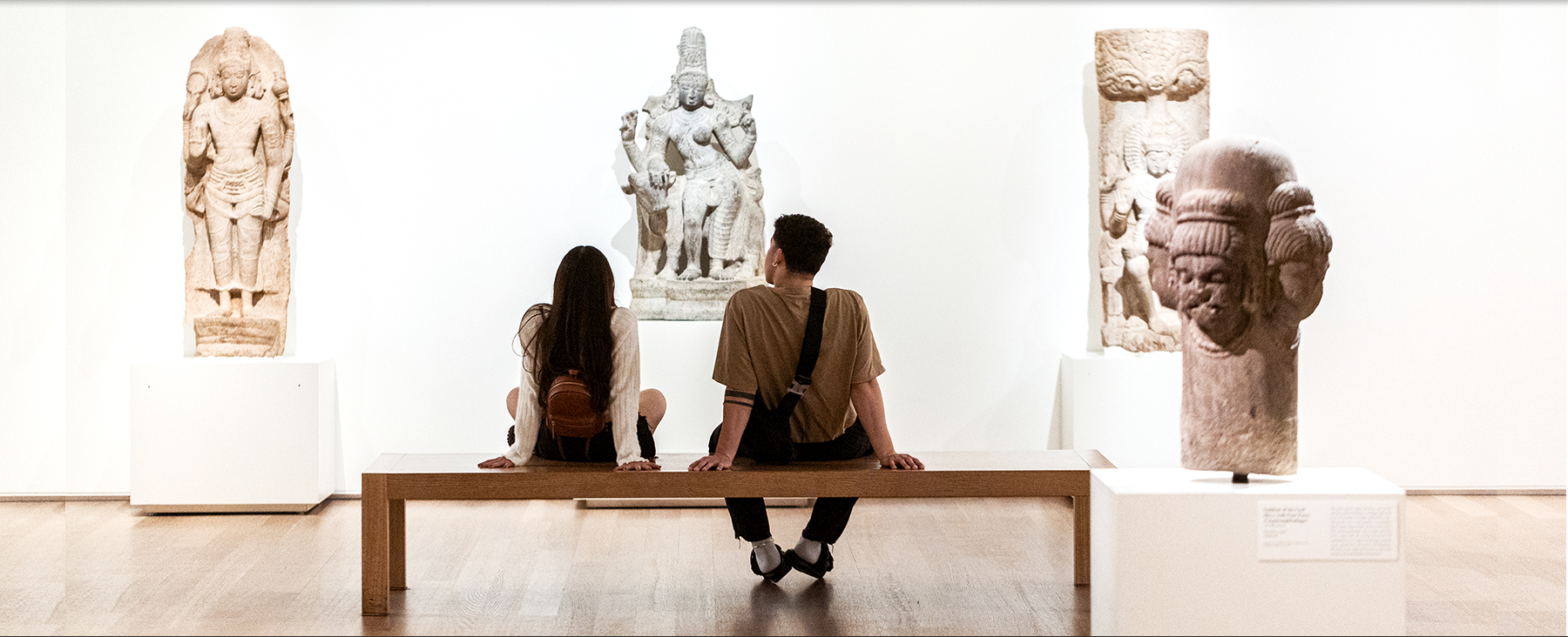 Two Loyola students sitting in front of artwork at the Art Institute of Chicago