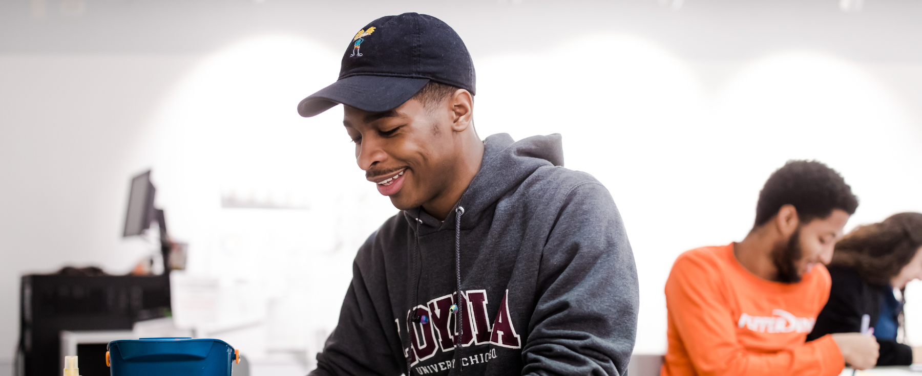 A student smiles while working in the classroom.