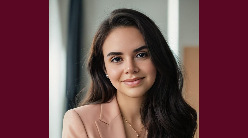 Headshot of a brunette person in a light pink blazer Headshot of a brunette person in a light pink blazer