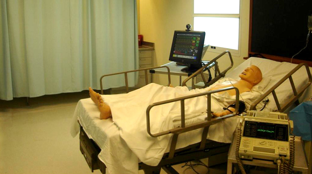 A training mannequin for medical procedures in a hospital bed
