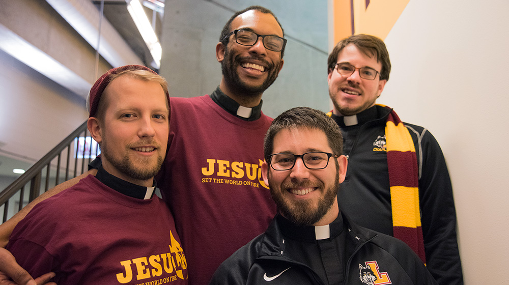Four Jesuits pose for a photo as they celebrate Jesuit Jam, an annual celebration for students hosted by the Society of Jesus