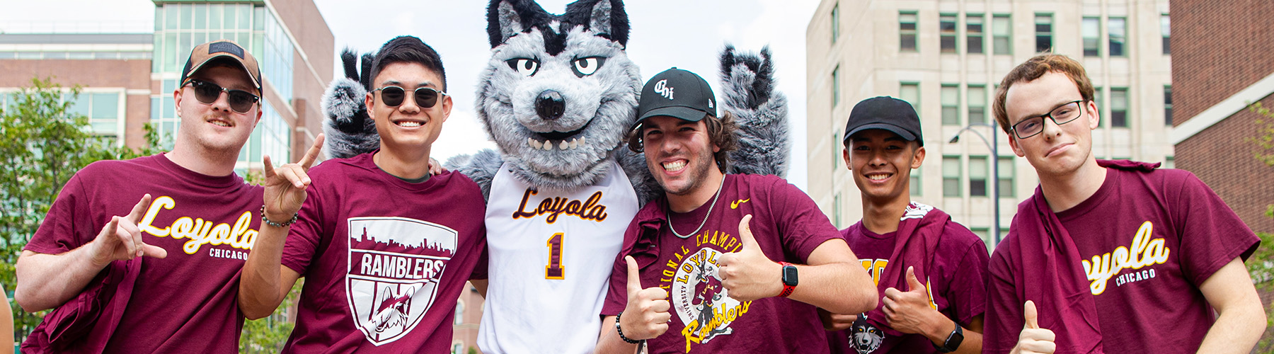 Loyola students in spirit-wear posing next to Lu-Wolf