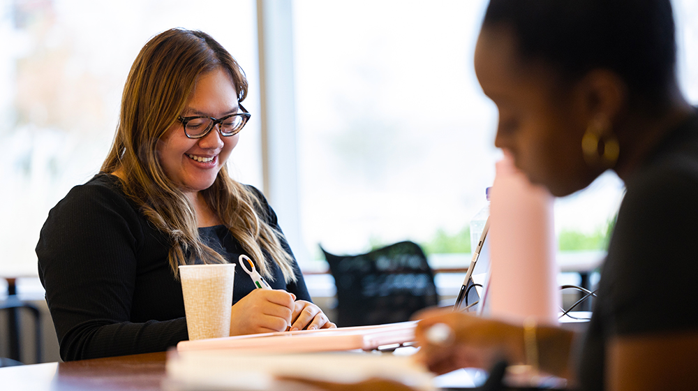 Loyola students study next to one another