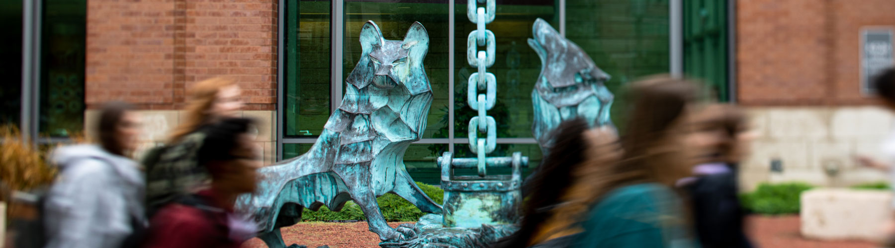 Loyola University Chicago students walking by the Lobo statue on Lake Shore Campus