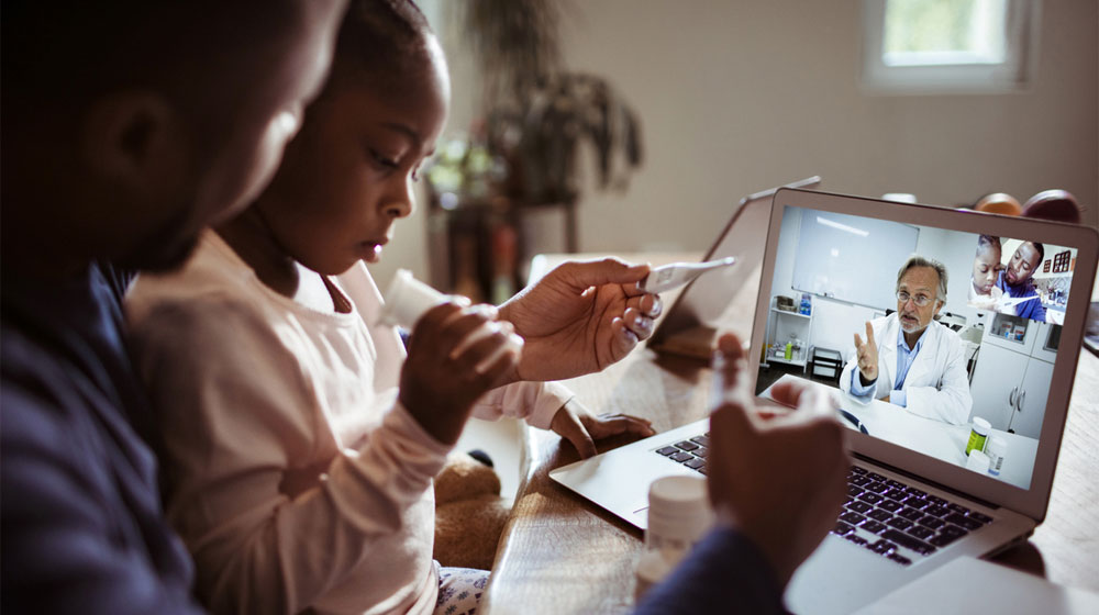 Father and child speaking to doctor using telehealth