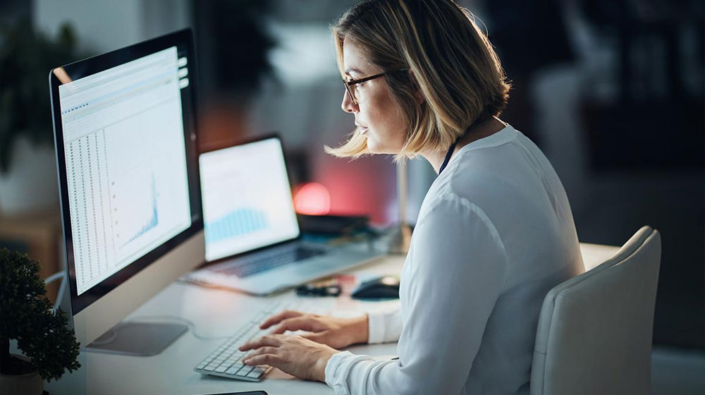 Woman seated at desk typing on computer