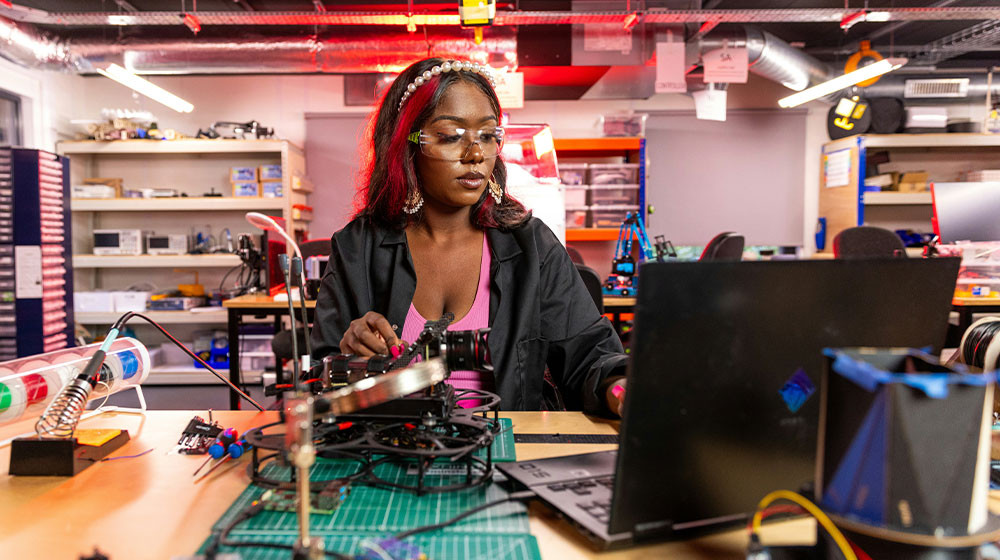 Woman working at a lab table on a small mechanical project