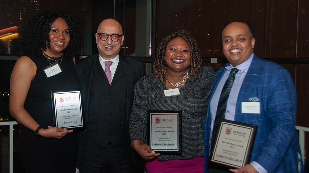 Three award receipients and Dean Behnam with their award plaques