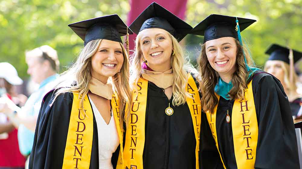 Three students in graduation gowns