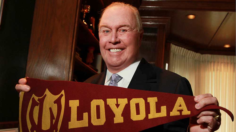 Michael Quinlan holding a Loyola flag