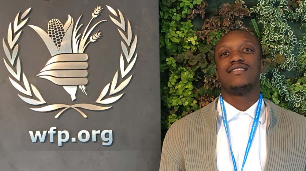 Saidi Mwanundu in front of WFP sign Saidi Mwanundu in front of WFP sign