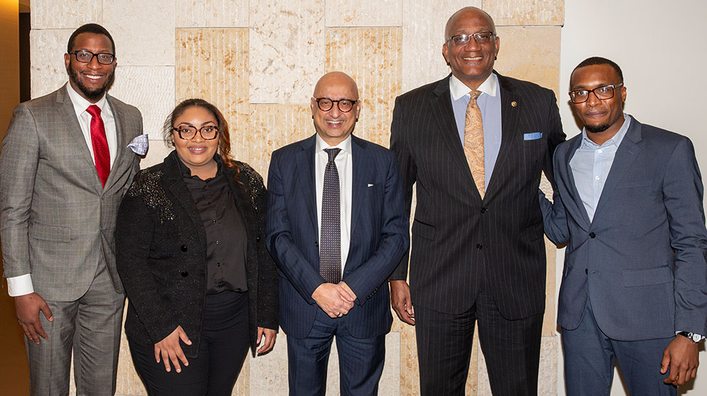 From left to right: Jonathan McGee, Amber Townsend, Michael Behnam, Marquis Miller and Emmanuel Ezeocha stand in front of a polished stone wall