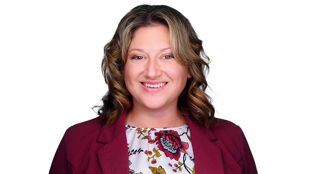 Headshot of Lisa McLuckie in a red coat and floral shirt Headshot of Lisa McLuckie in a red coat and floral shirt