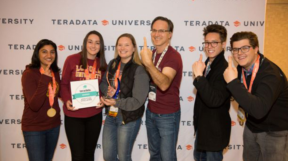 Group of five students and a professor posing as champions with their award