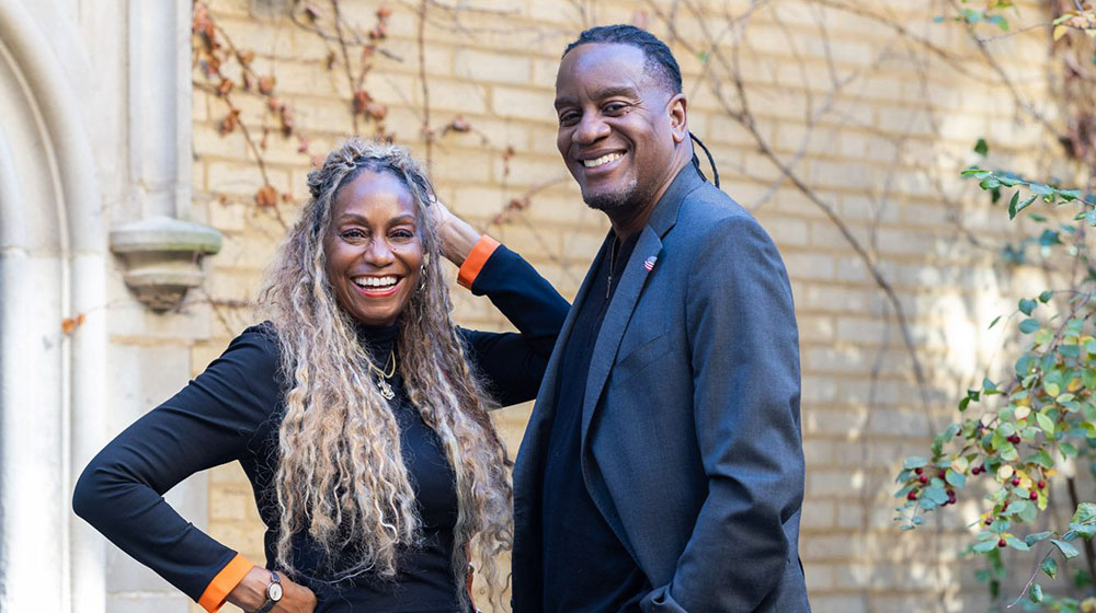 Jay and LeJune Yancy pose outside a brick wall.
