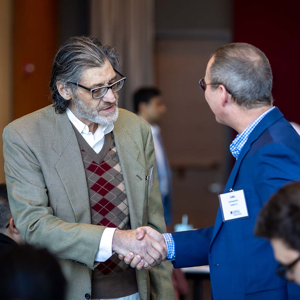 Steven Keith Platt shakes hands at the AI in Financial Services 2026 conference