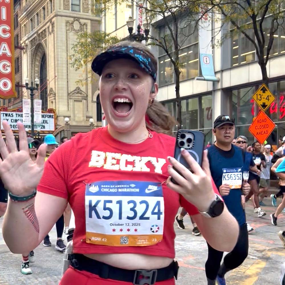 Becky Lindquist running the 2026 Chicago Marathon outside the Chicago Theater