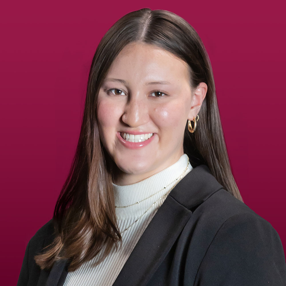 Headshot of Jillian Cole on a maroon background