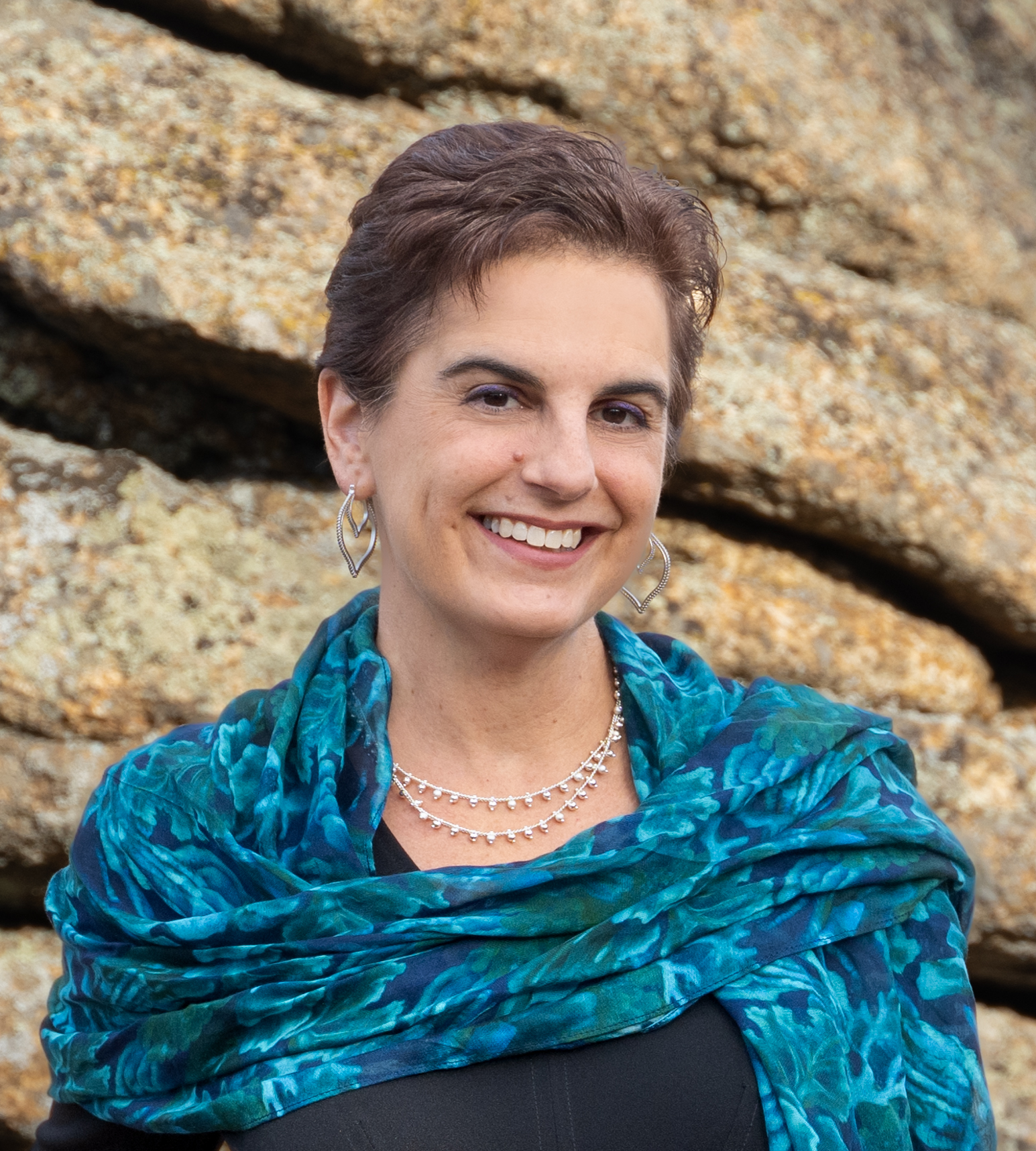 Stacy Garrop standing in front of a rock, seen from the shoulders up.