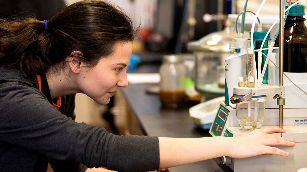 A student working in the Biodiesel Lab where the School of Environmental Sustainability processes used cooking oil into fuel for shuttle buses used on campus to transport students