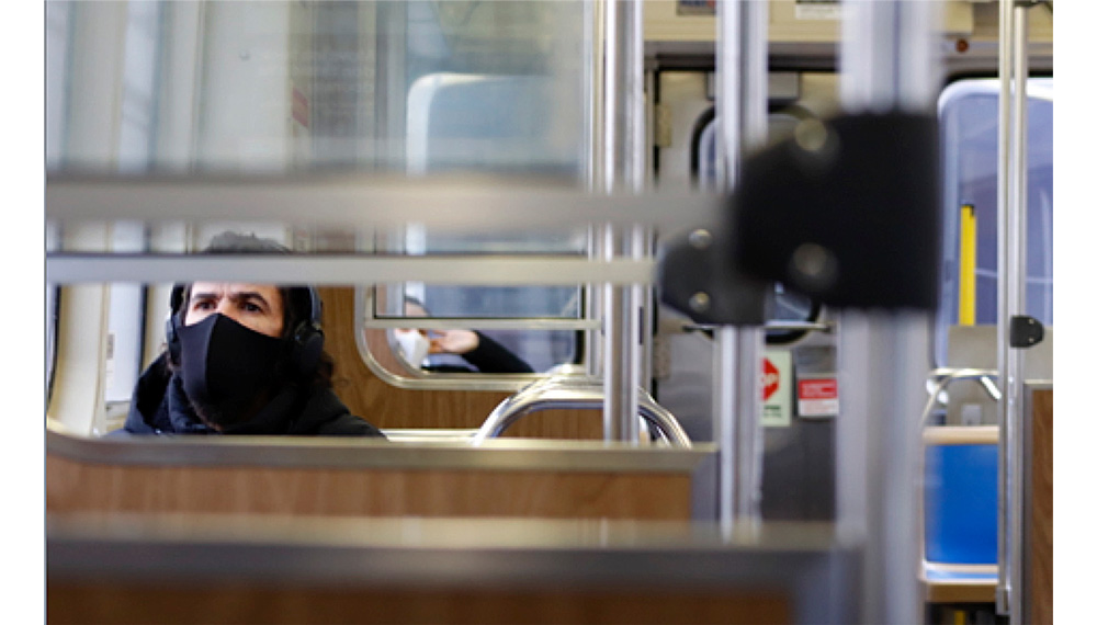 This page: Scene of a passenger on a Chicago L train.  Photo by Emma Ingrassia. Previous page: Sips, a local artist, paints a wall in Chicago. Photo by Jenny Chase