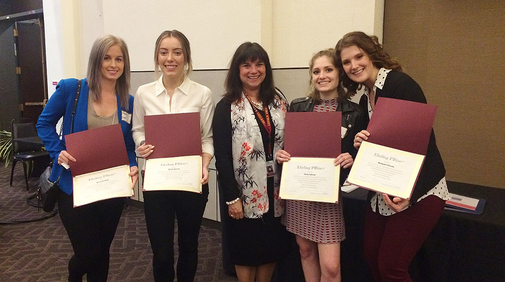 Students of the Anti-Cruelty Society team posed with their professor, Virginia Mann (center), after winning a scholarship for their nonprofit campaign. (Students left to right: Amanda Klotz, Kelcie Boring, Carly Sullivan, Bridgette Potratz)