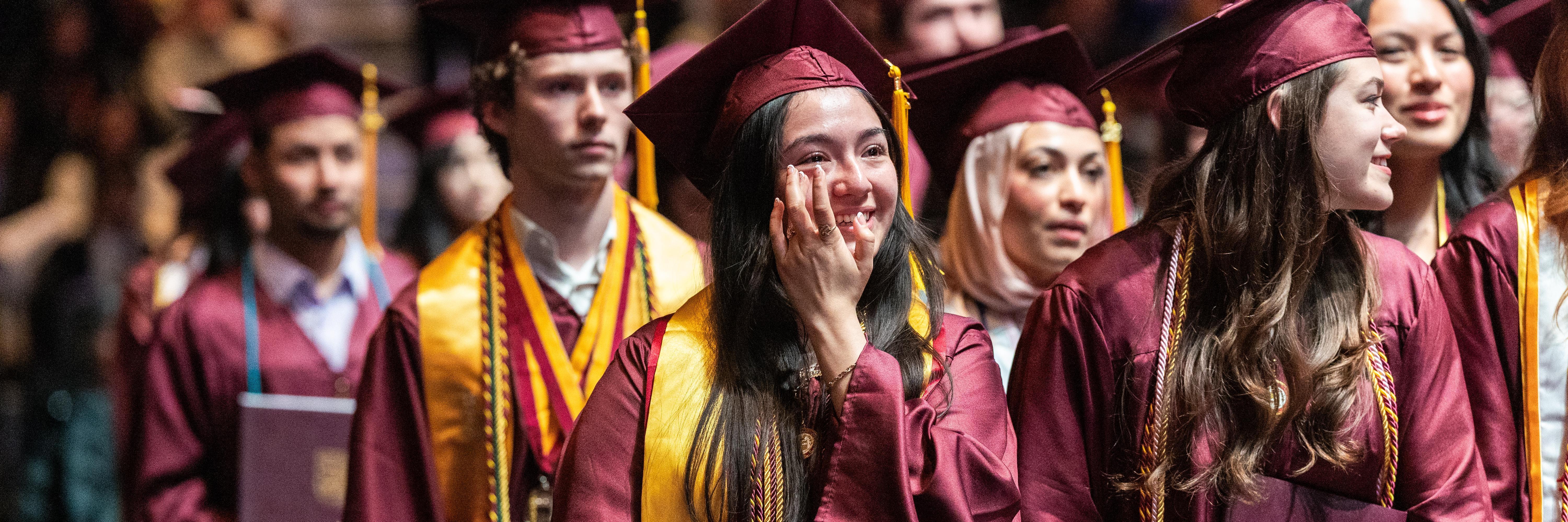 A School of Social Work student wipes away tears of joy during 2026 commencement