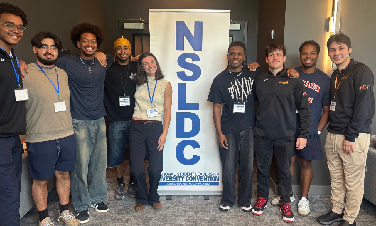 Students from the Rambler Brotherhood Project pose for a group photo in front of a banner at the National Student Leadership Diversity Convention.