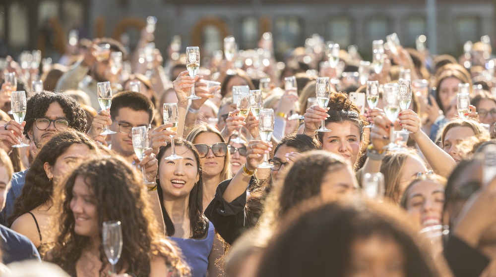 A crowd of graduating students raise their Champagne flutes together during Senior Toast.