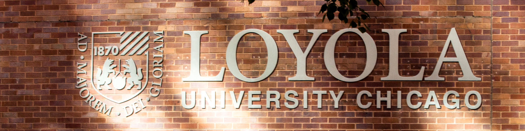 Loyola University logo metal signage on a brick wall Loyola University logo metal signage on a brick wall