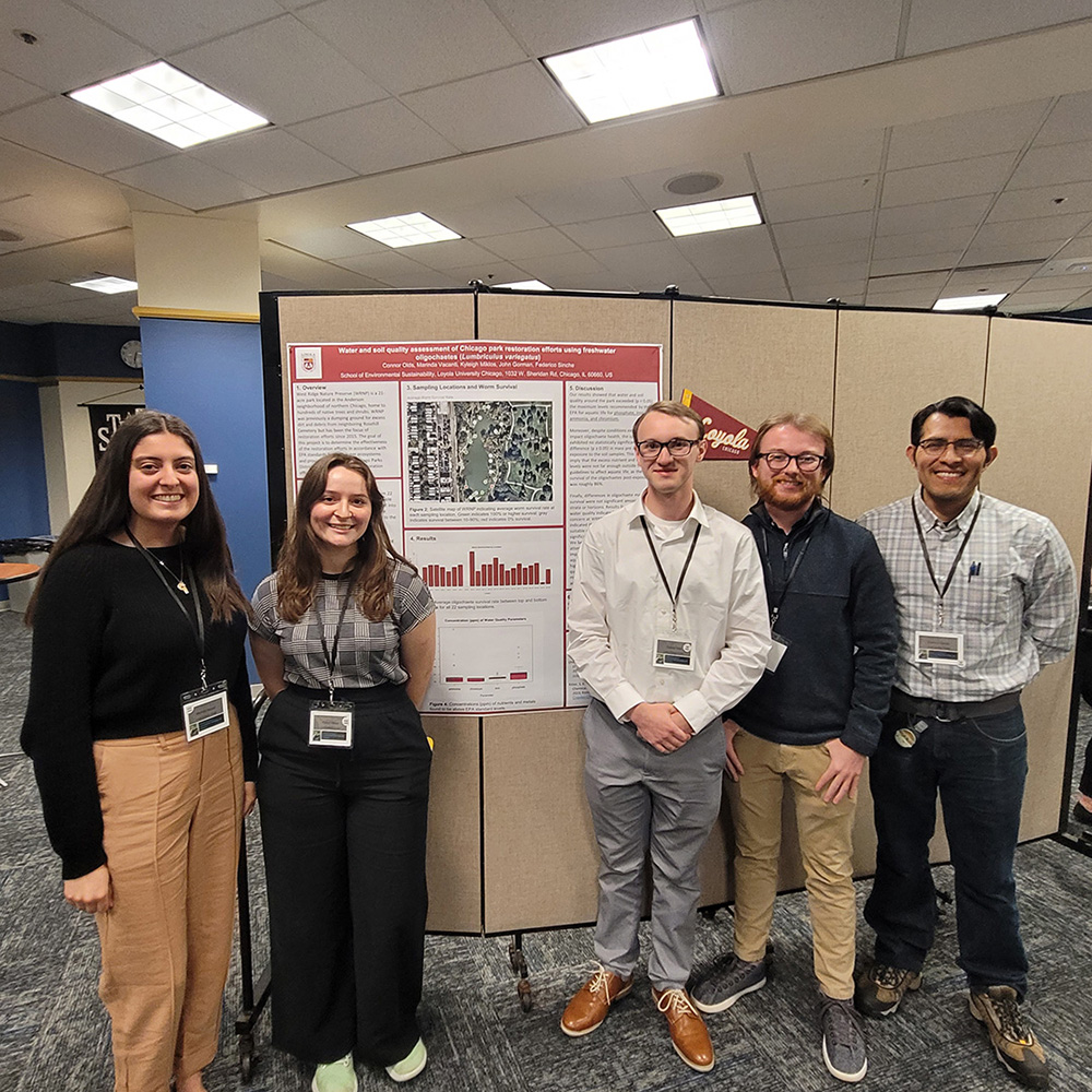 student researchers with their poster at a conference