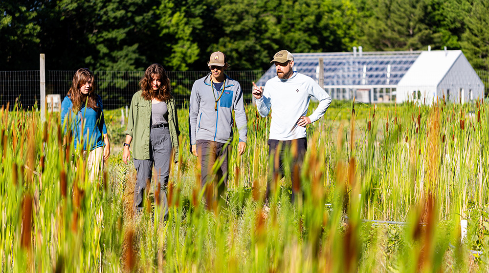 Brian Ohsowski and Shane Lishawa standing in a field with two students