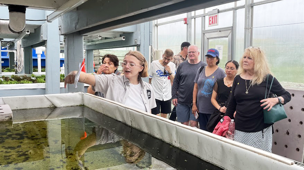 Bailey Uttich leading a tour of the aquaponics facility at the Farm on Ogden