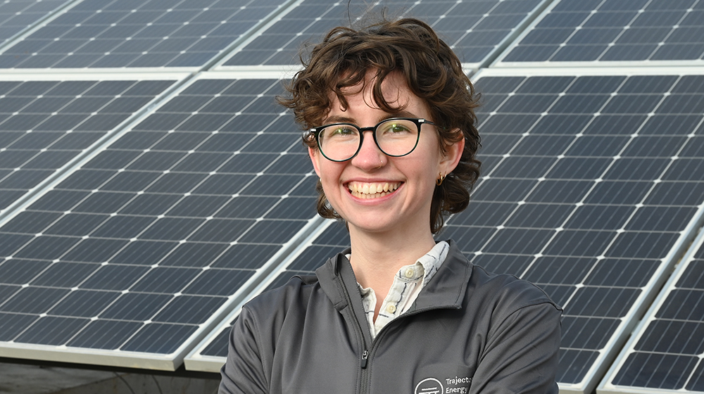 Emily Hammermeister standing in front of solar panels